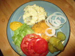 Plate full of burgers and potato salad.