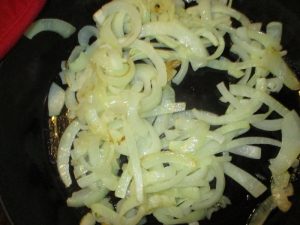 skillet of white sliced onions after cooking for 15 minutes
